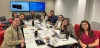 The international admissions team sits around a table smiling at the camera.