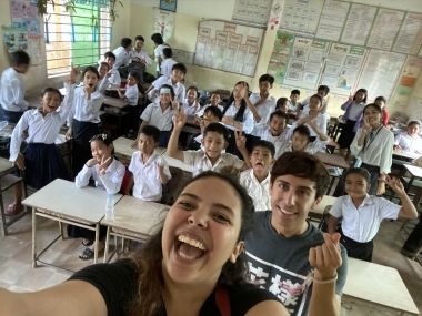 UA Study Abroad Student Reina Salgado taking selfie with elementary school students in classroom, on GEL program in Southeast Asia.