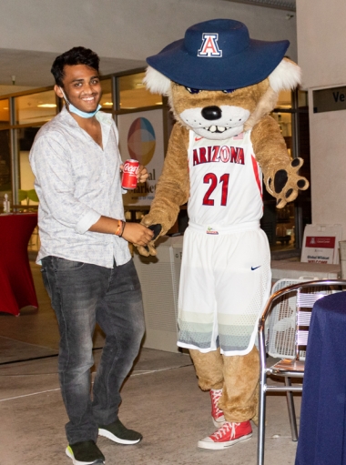 International student shakes hand with Wilbur Wildcat at the 2021 Global Wildcat Welcome Party