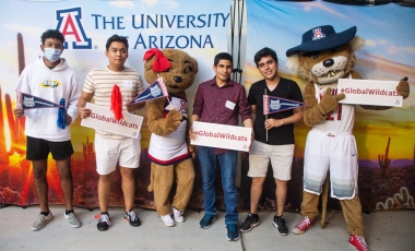 International students holding #GlobalWildcats signs with Wilma and Wilbur Wildcat at the 2021 Global Wildcat Welcome Party