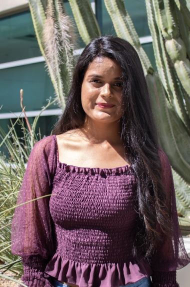Shreya Singh wearing a maroon shirt and standing in front of a cactus on UArizona Campus