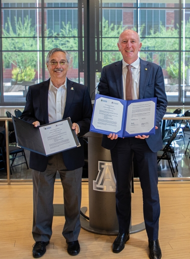 Dr. Steven Goldschmid, at left, and Hon Stephen Dawson MLC, at right, holding signed MOU documents