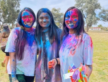Ananya, center, with two friends celebrating Holi. All three are covered with colored paint powder, part of the Festival of Colors