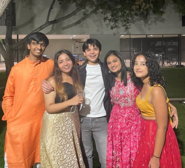 Ananya, second from right, with a group of international student friends, dressed in colorful, shiny gowns for a special event.