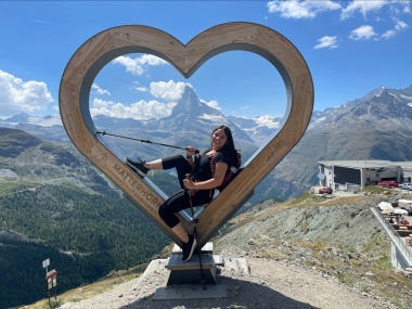 Jennifer sits inside a heart sculpture with the Matterhorn in the background